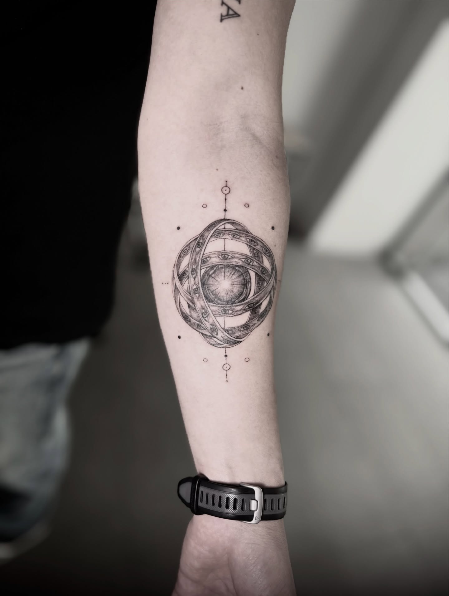 Geometric tattoo of an eye inside orbital rings